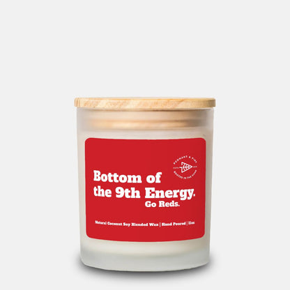 Candle with a red label and wooden lid on a white background