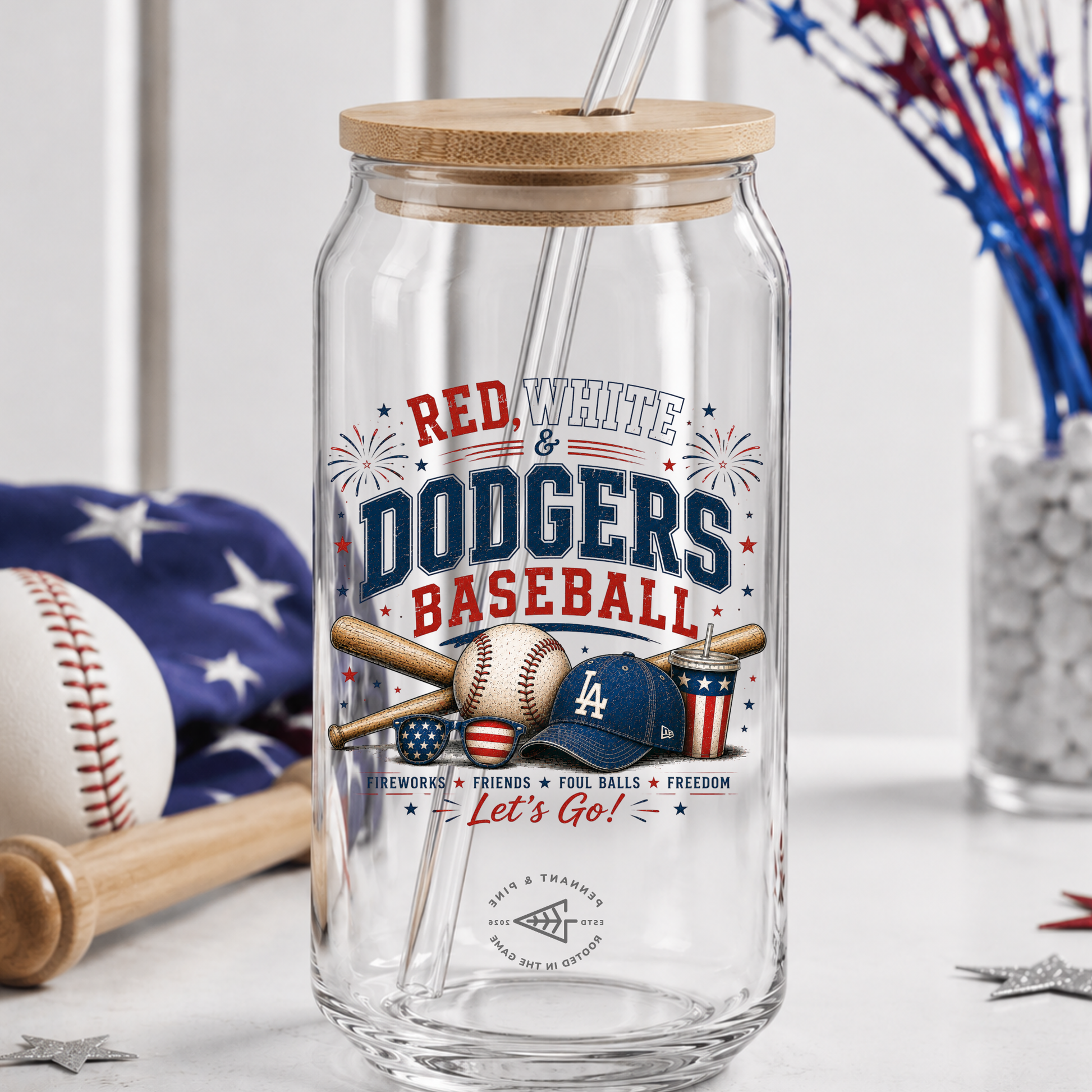 Clear glass tumbler with wooden lid featuring 'Red, White & Dodgers Baseball' design on a table with sports-themed decor.