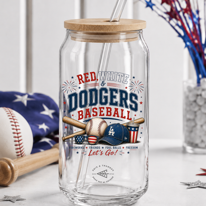 Clear glass tumbler with wooden lid featuring 'Red, White & Dodgers Baseball' design on a table with sports-themed decor.
