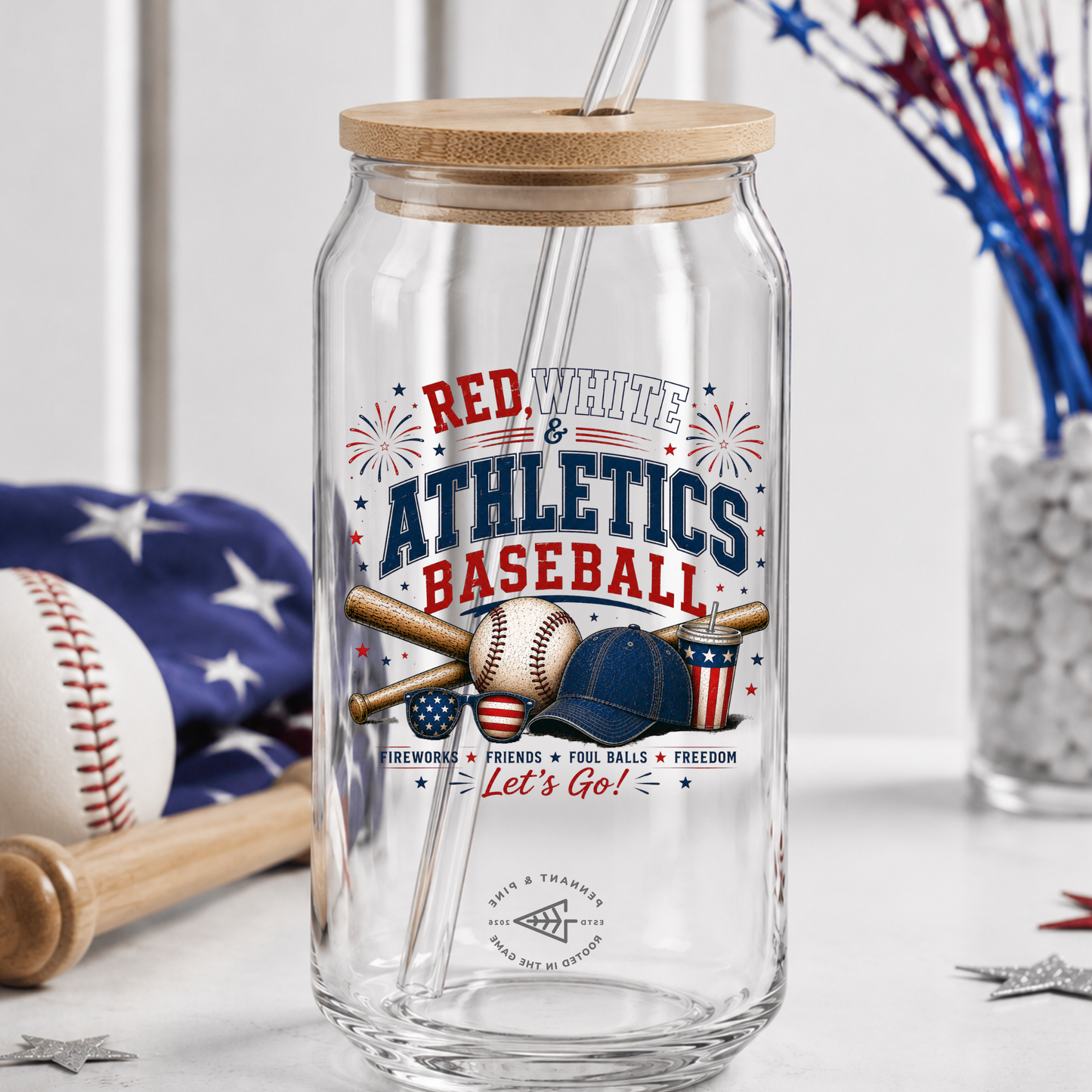 Clear glass tumbler with wooden lid and baseball-themed design on a white surface.