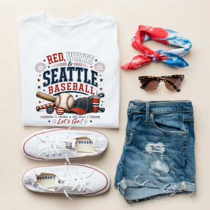 White t-shirt with 'Red, White & Seattle Baseball' design, white sneakers, denim shorts, sunglasses, and a colorful headband on a beige background.
