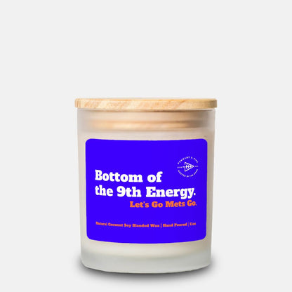 Candle with a blue label and wooden lid on a white background