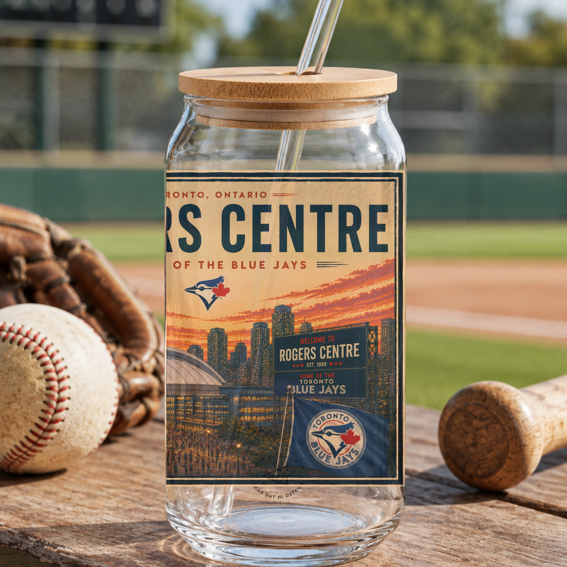 Glass tumbler with a lid featuring the Rogers Centre of the Blue Jays on a baseball field background.