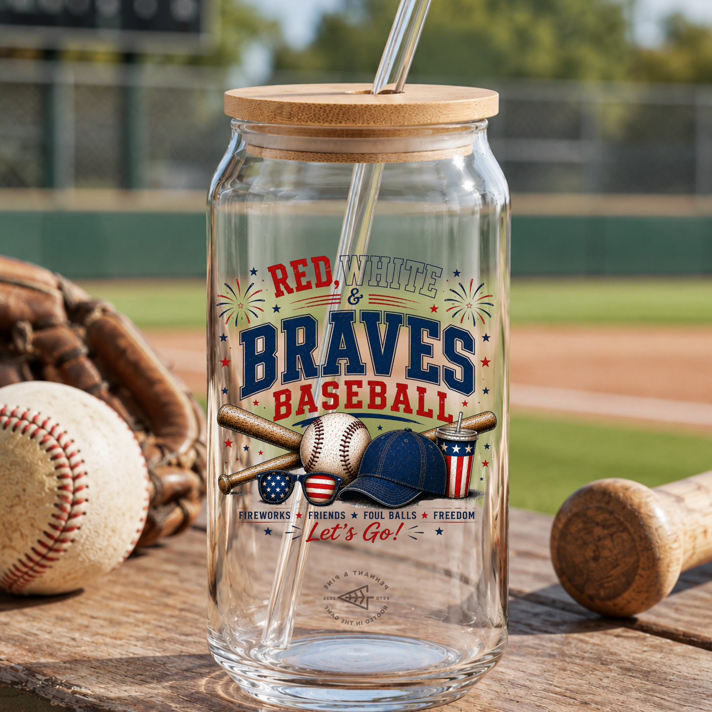 Glass tumbler with wooden lid and straw, featuring 'Red, White & Braves Baseball' design, on a baseball field background.