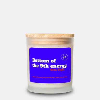 Candle with a blue label and wooden lid on a white background