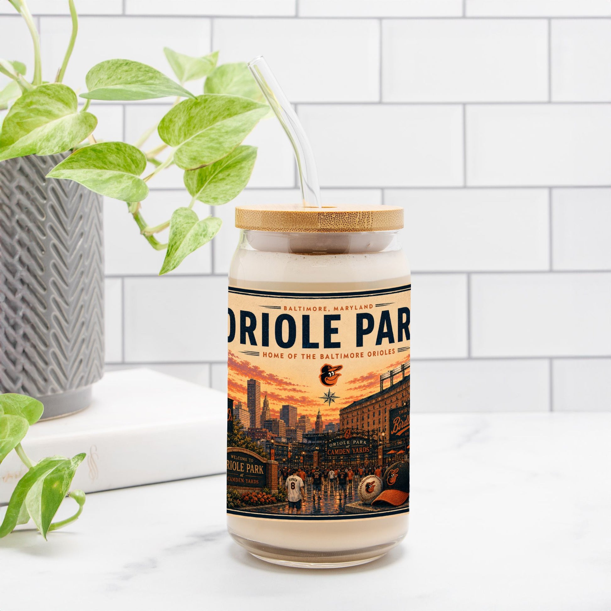 Jar with a decorative label featuring 'Oriole Park' on a white surface with a plant in the background.
