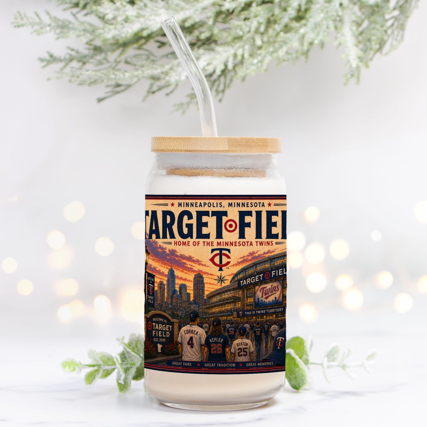 Tumbler with Target Field design and wooden lid on a white background with blurred lights and greenery.