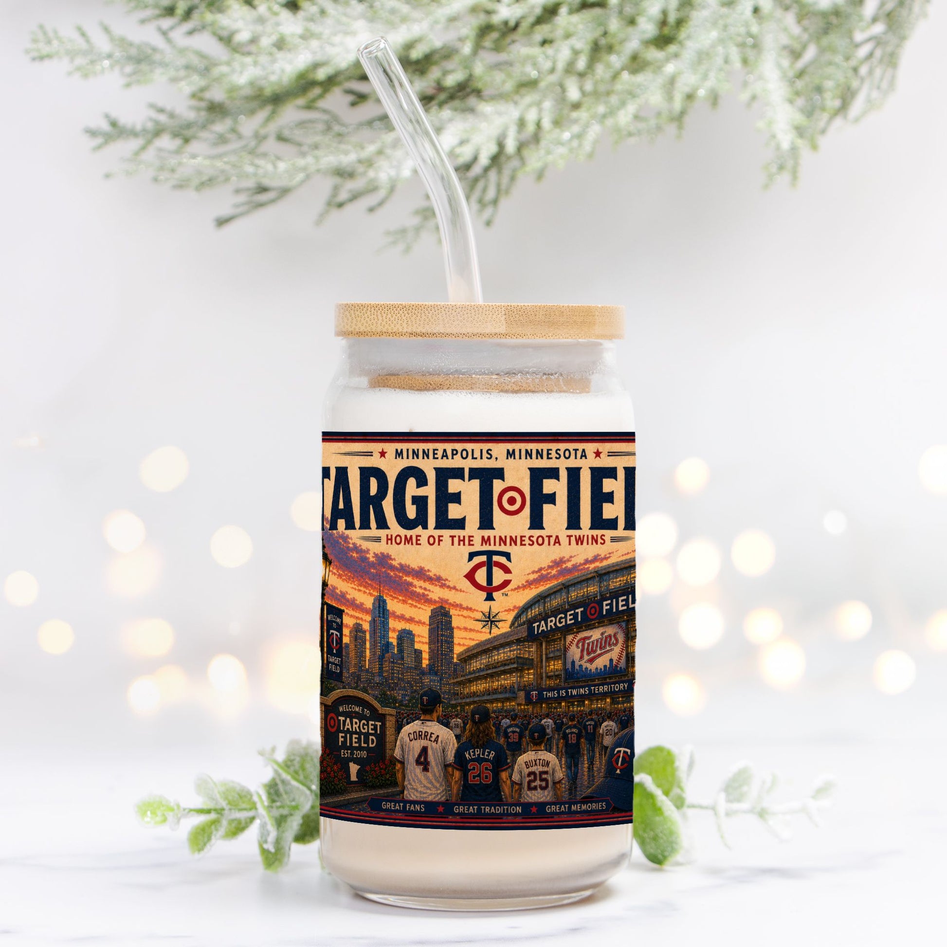 Tumbler with Target Field design and wooden lid on a white background with blurred lights and greenery.