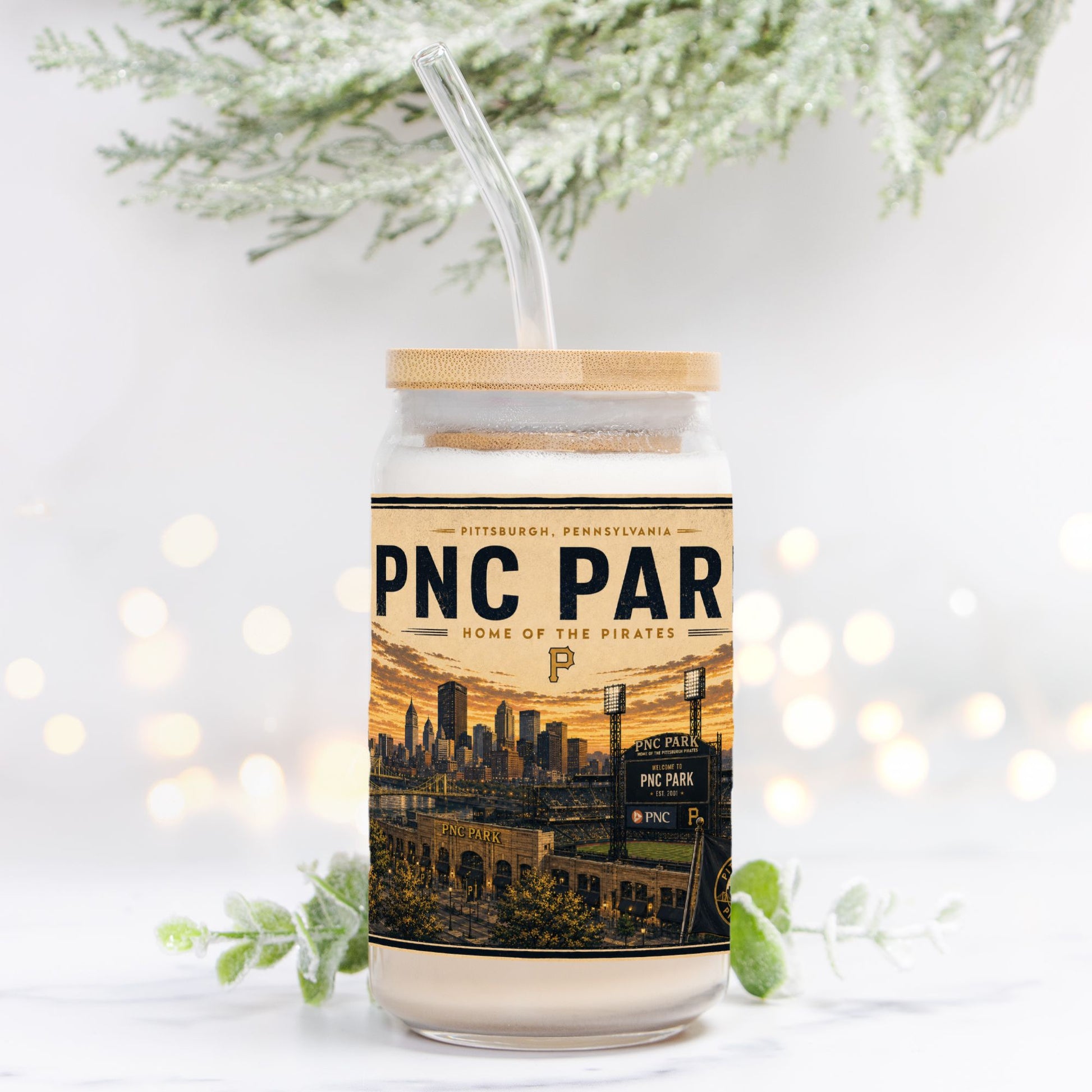 Tumbler with PNC Park design on a white background with blurred lights and greenery.
