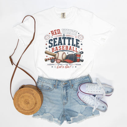 White t-shirt with 'Red, White & Seattle Baseball' design, denim shorts, white sneakers, and a woven bag on a white background.