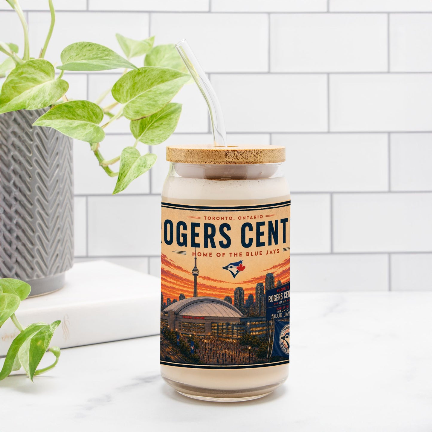 Candle with Rogers Centre label on a white surface with a plant in the background