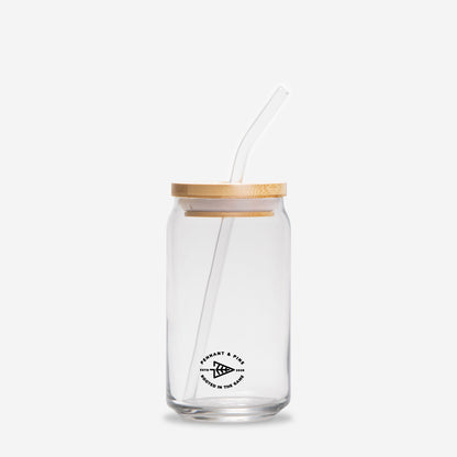 Clear glass jar with wooden lid and straw on a white background