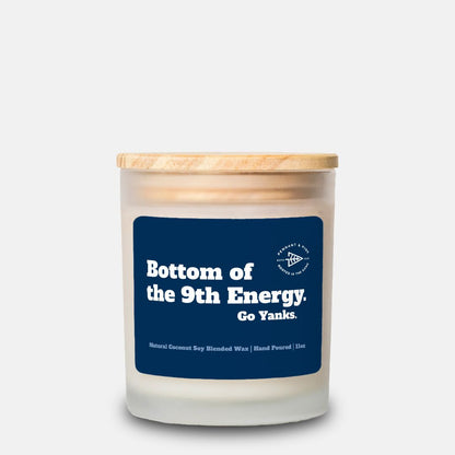 Candle with a blue label and wooden lid on a white background